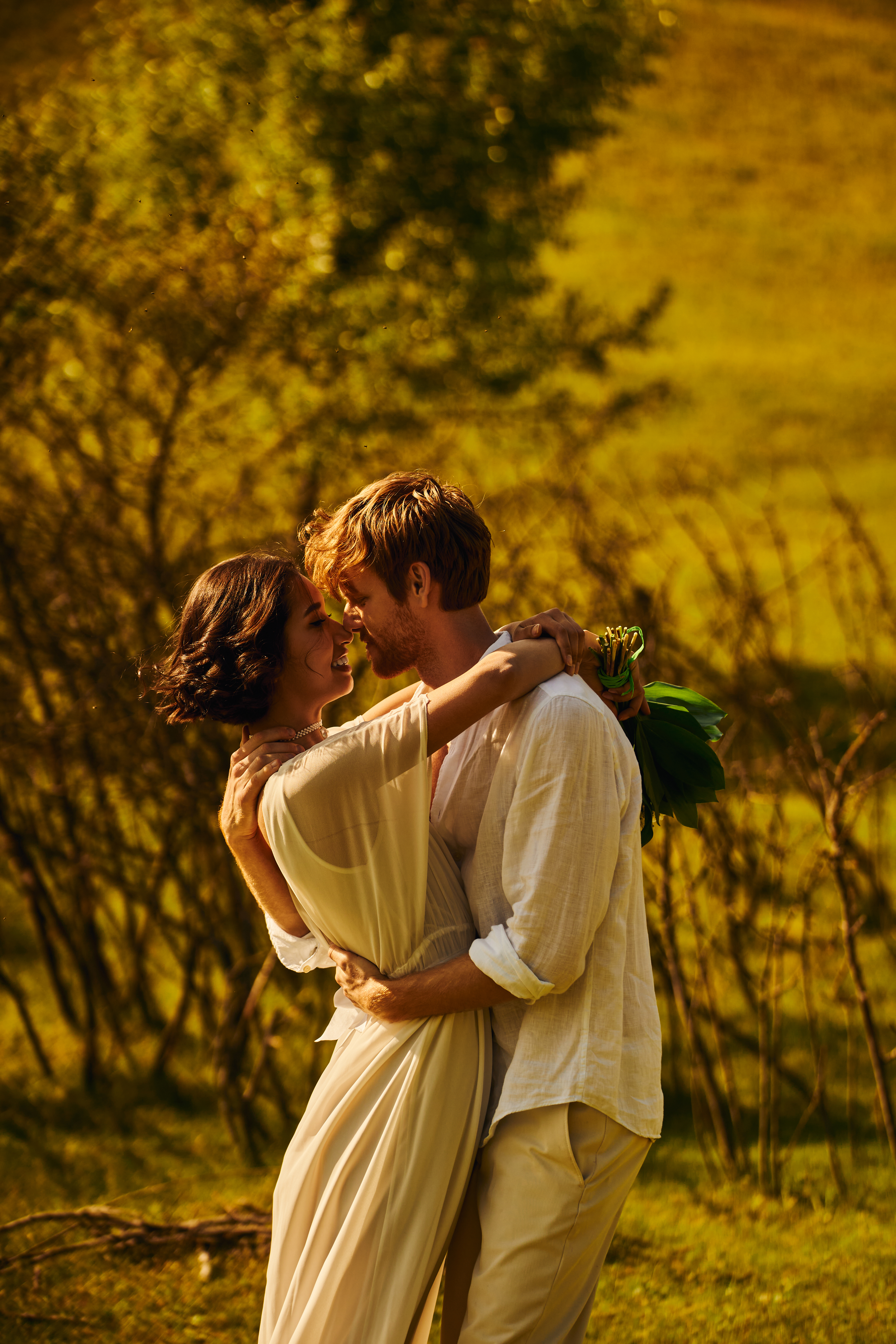 rustic wedding, elegant interracial newlyweds embracing in countryside setting, side view